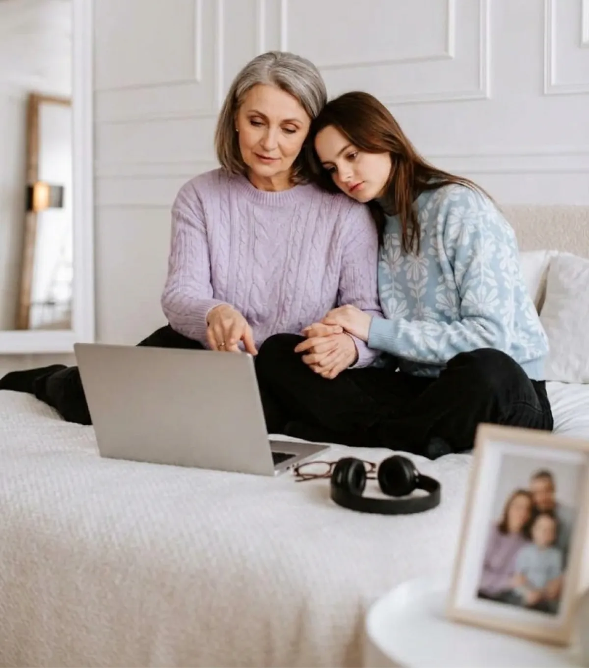 A mother and daughter looking through photos on a laptop